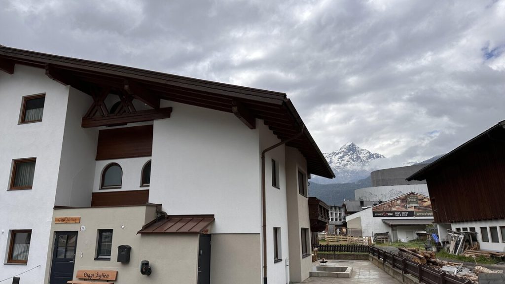 Side of Giggi Hytten with mountain views beyond the chalet